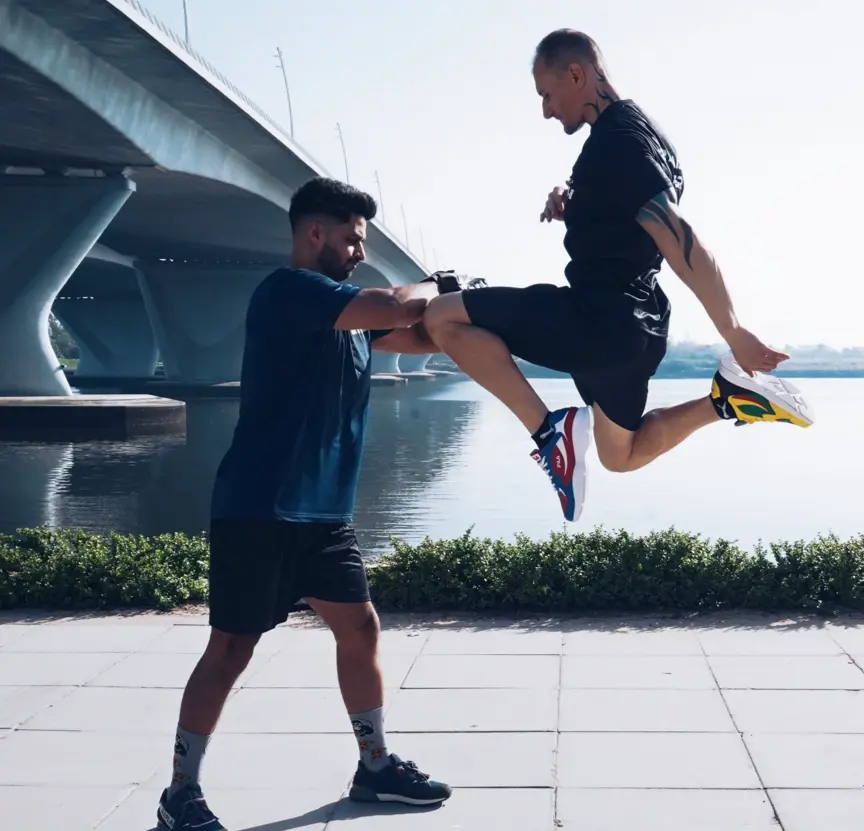 FlexAndPunch fitness trainers displaying Muay Thai knee strike and defence